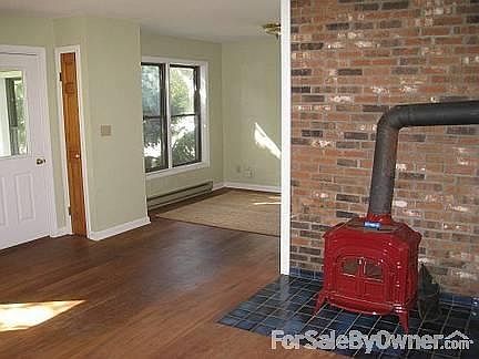 Inside, living room/part view of kitchen : Pot Belly, cast - iron stove , brick walls, windows, wind