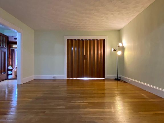 Large living room with private office/guest space with custom doors for privacy.