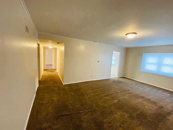 View from front door entrance looking at the living room and hallway to a bedroom.