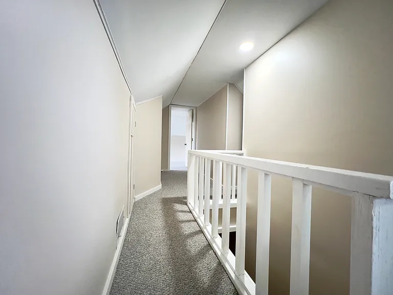 Top of stairwell. Hallway to the 3rd bedroom on the left with hidden storage on the right