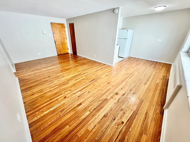Experience the warmth of this inviting wood-floored living area, seamlessly leading into a functional kitchen. Experience the warmth of this inviting wood-floored living area, seamlessly leading into a functional kitchen.