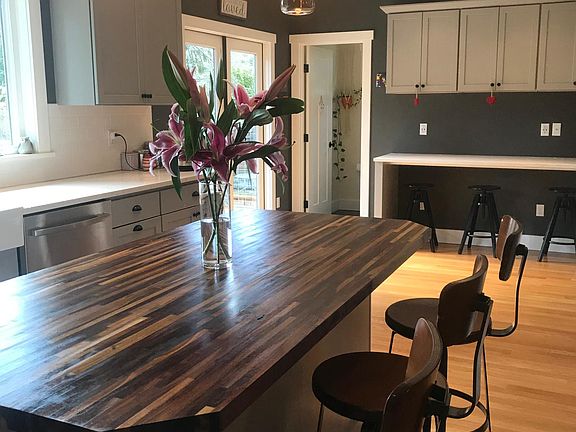 Large kitchen with high ceiling, gas range and island, see desk area off to side (desk stools will remain in the house)