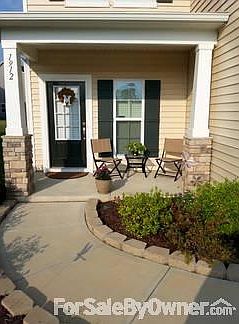 Relax on the front porch while watching the kids play in the green space