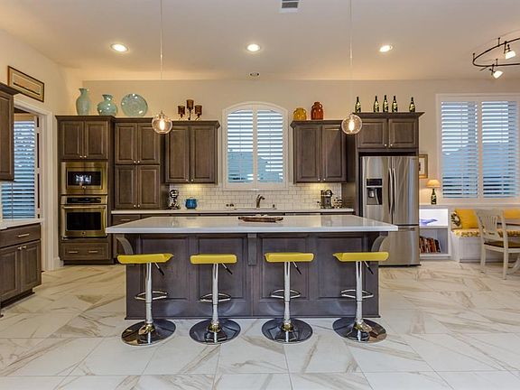 Beautiful quartz counter tops, gray wood cabinets, under-counter and over cabinet up-lighting creates a warm, richly elegant ambiance. There is an abundance of counter space for food preparation and entertaining guests at the same time.