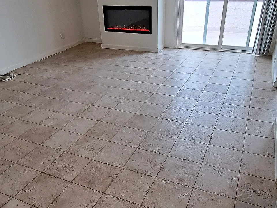 SUNNY LIVING ROOM WITH FIREPLACE OPENS TO KITCHEN AND BALCONY.