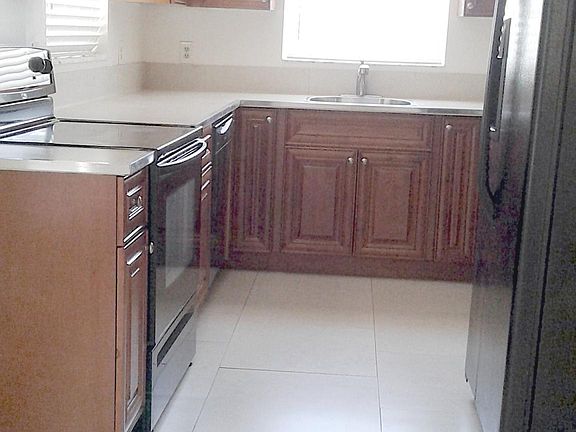 Solid cherry Kitchen cabinets and tiled countertops.