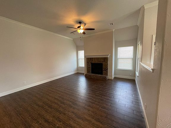 Living room with gas fireplace and mantle. Ceramic tile (wood appearance). Ceiling fan.