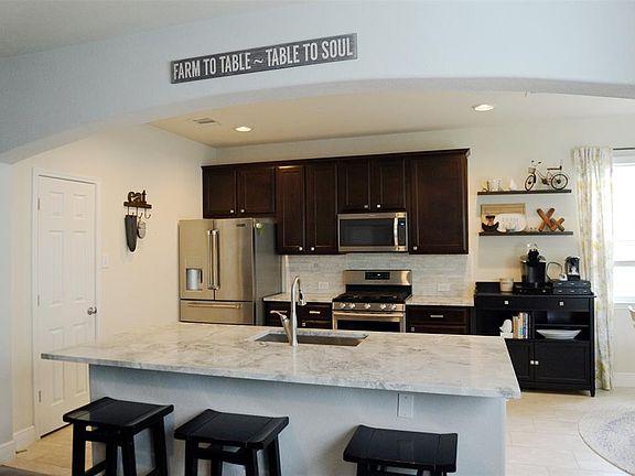 Beautiful kitchen with large single level Quartzite island and counters, 42" soft-close wood cabinets and stainless steel appliances.