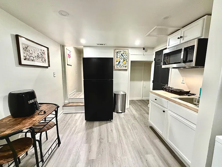 Efficient eat-in kitchen with ample cabinetry, sink, microwave, and full-size refrigeratorideal for daily meal prep.
