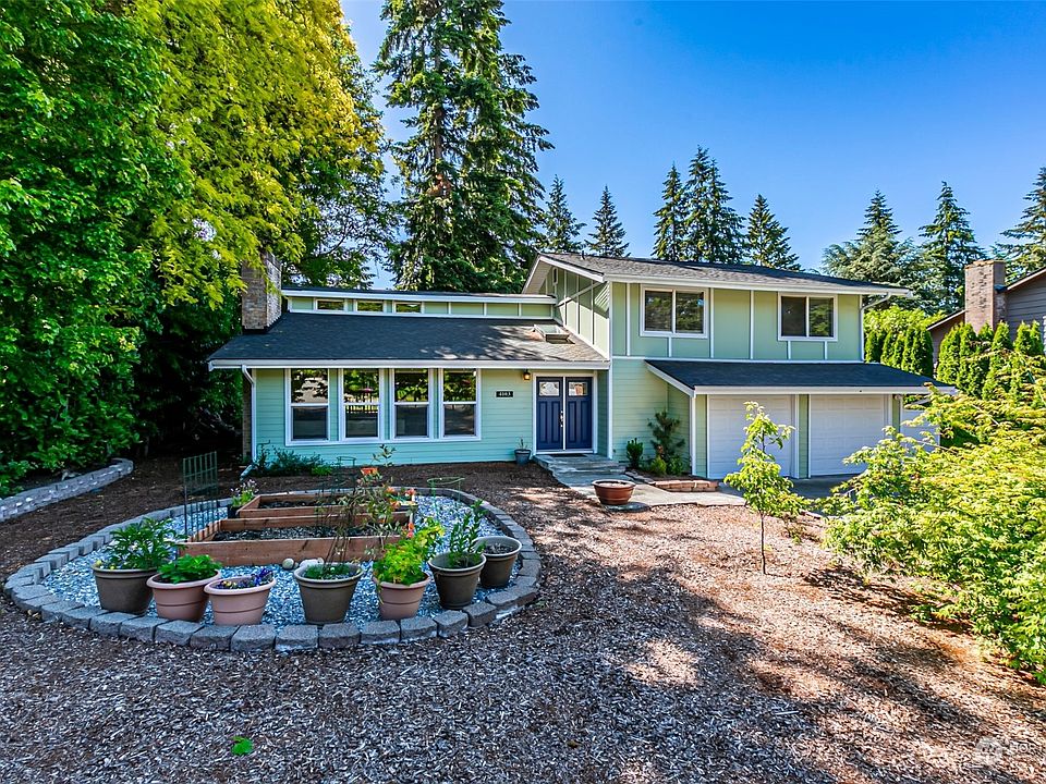 Front yard with raised garden beds and fruit trees.>