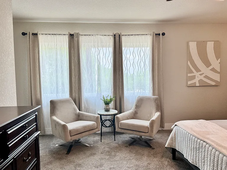 Master bedroom features a seating area
