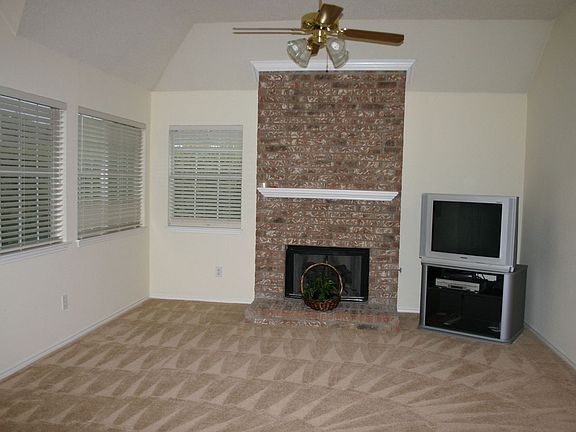 Den has ceiling fan, gas logs and access to backyard.