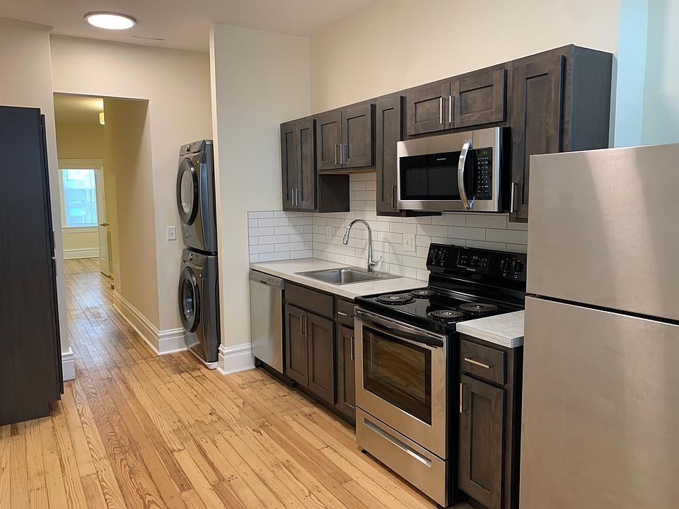 Kitchen with new stainless steel appliances, and stacked washer/dryer.