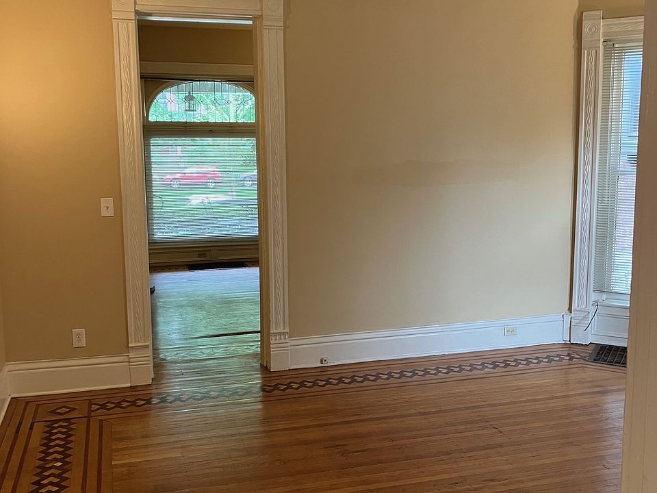 bedroom showing inlaid floor and passage to living room, with front window onto Court