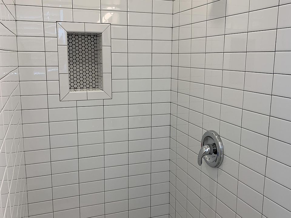 New shower/fixtures, with subway tile walls & penny tile floor & niche