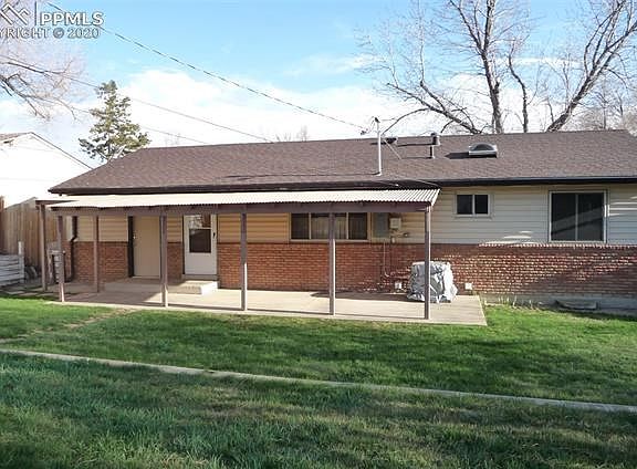 ANOTHER view of back of home. Tan door on the left is the man door to the oversized garage and white screen door enters into the