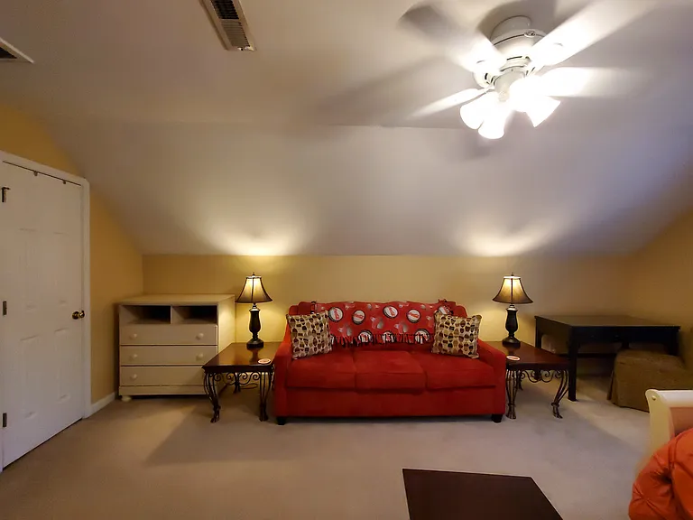 Closet, Hampton Bay ceiling fan/light with remote/, small chest of drawers, front angle of couch, end tables, lamps and desk with chair.