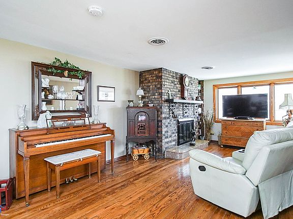 Enter the front door and you are in the large family room.  Fireplace (1 of 2), hardwood flooring, two Pella bay windows with be