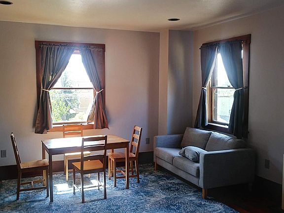 Main Room - table, West window, sofa, NW window, wall heater