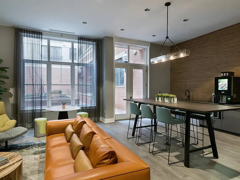 Clubroom with multiple seating areas and coffee bar.