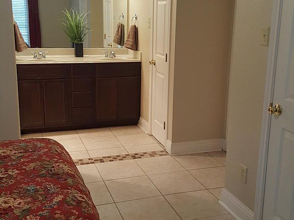 View of primary bedroom with double sink vanity