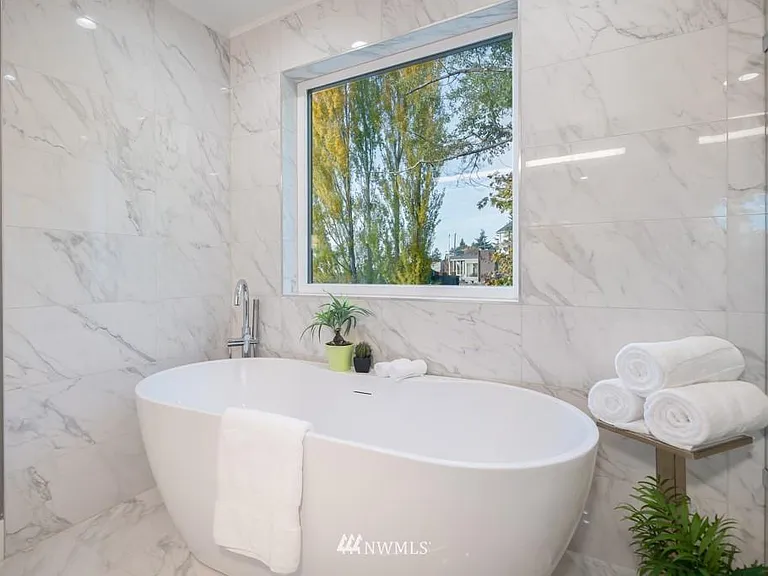 Gorgeous master bathroom with a grand tub, surrounded by marble walls