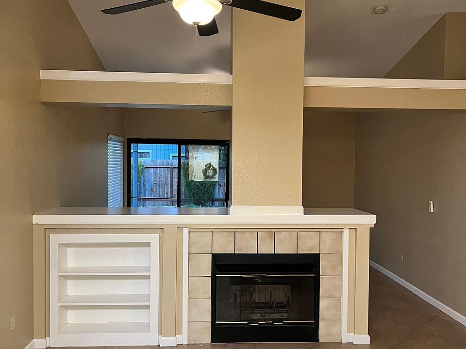 Love this spacious living with double faux (dura flame type logs only) fireplace and built in shelving on both sides.