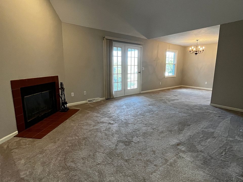 living room, French doors leading to balcony, fire place, tray ceiling, dining room