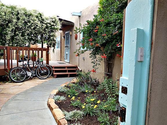 Inside the gate to Unit B: small patio, flower garden and raised, wooden deck.