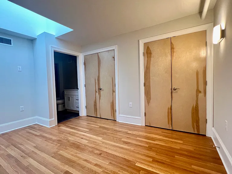 En-suite bedroom showing double closets, door to bath.