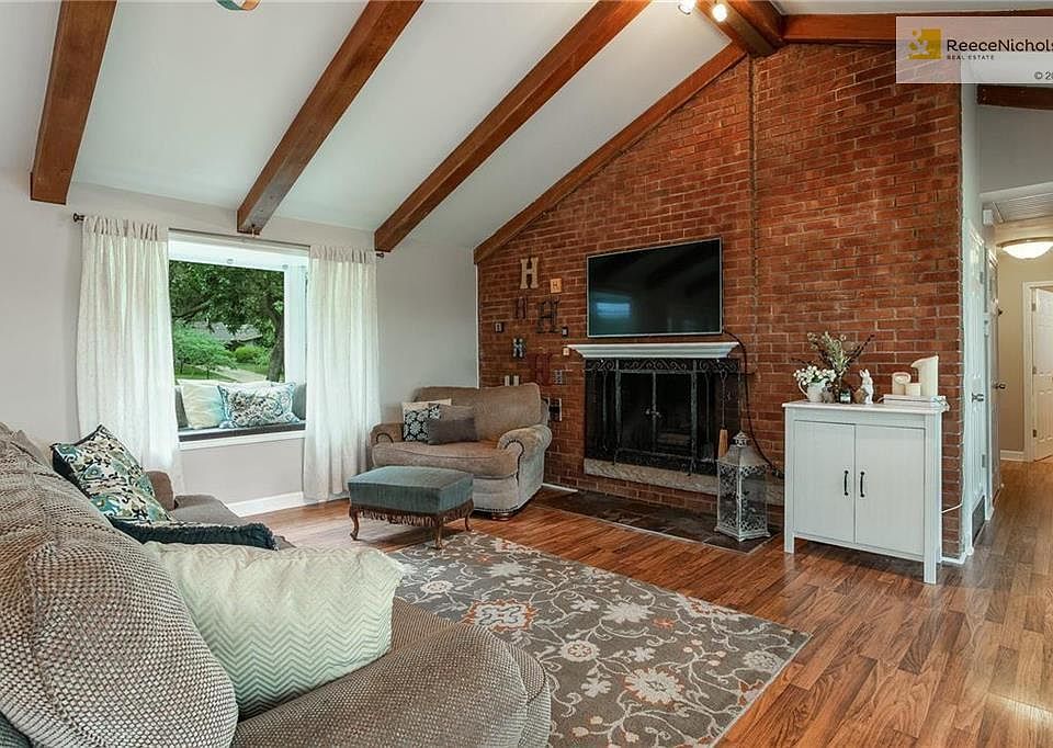 Large, open living room flush with natural light from wall of windows on the back.