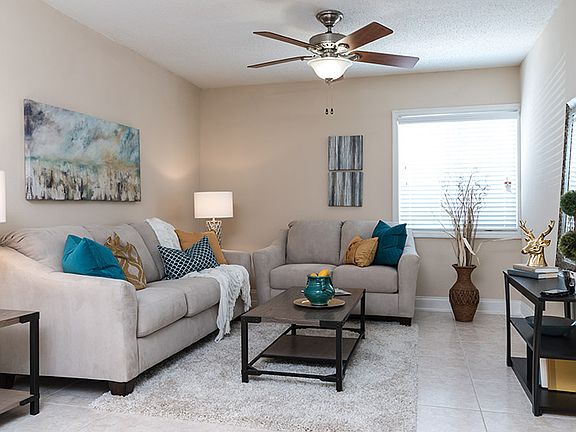 Open living room with tile flooring and a ceiling fan