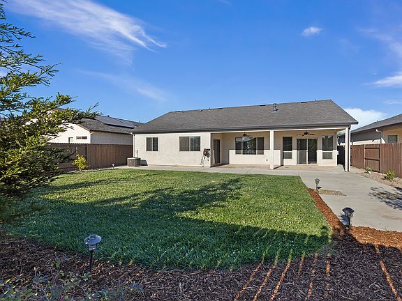 Large yard with grass, covered patio. Landscaping included.