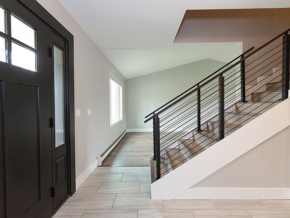 Entry way featuring new railing, door, flooring, trim and paint, all upgraded in 2021.