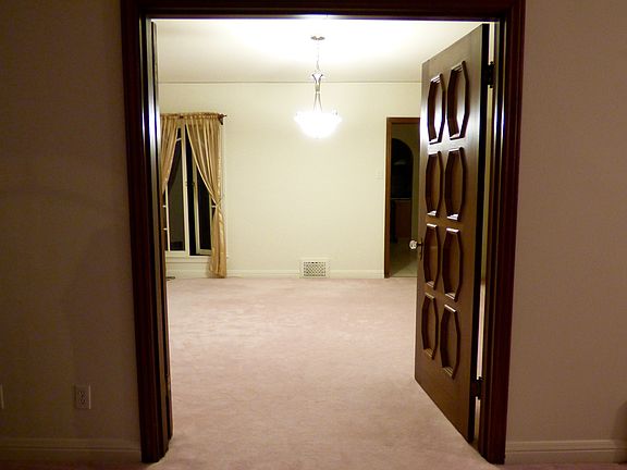 Gum wood wainscoting trim and doors leading to dining room