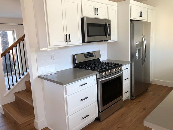 Galley kitchen. Gas stove, french door refrigerator with ice maker/water in door, microwave, and pantry with pull-out shelves.