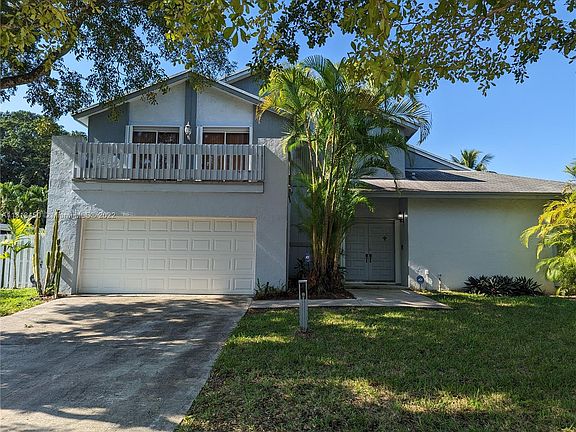 Notice the balcony on the second level, the double door front entry to the Foyer that opens into the large  livingroom accented by the the fireplace and exposed wood beamed ceiling!All sliding glass doors of the livingroom & diningroom open to the large s
