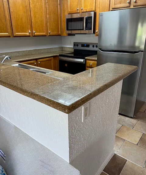 Kitchen with new stove, microwave and refrigerator.