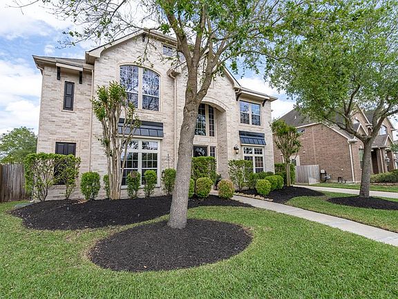 Lush landscaping and mature trees provide a beautiful atmosphere as you wander up the walkway to the arched front porch! A stately brick exterior with classic touches includes arched walkway, tinted windows and tin overhangs with gables!