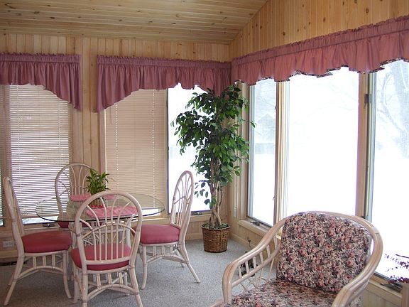 Cozy Sunroom offers wonderful view of large backyard.