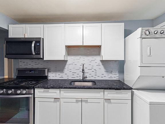 Undermount stainless steel sink, washer and dryer in unit.