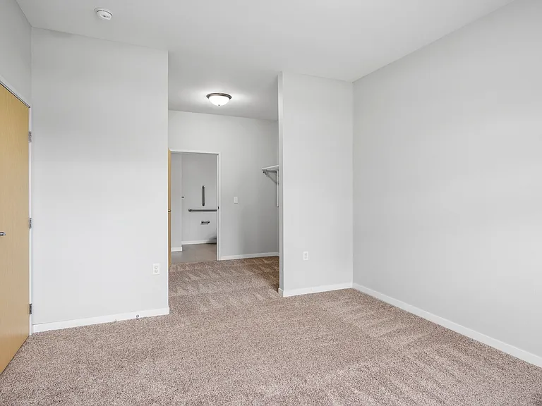 Bright and inviting bedroom with plush carpet, neutral wall tones, and a spacious closet. Bright and inviting bedroom with plush carpet, neutral wall tones, and a spacious closet.