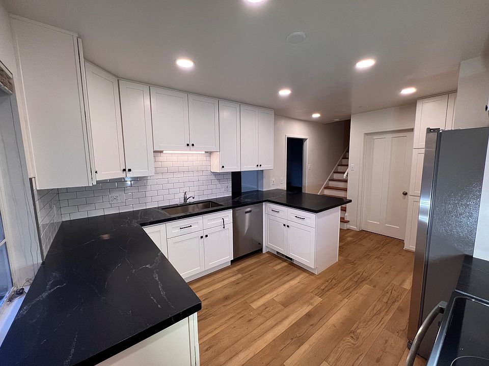 Brand new roomy chef's kitchen with stainless steel appliance and natural stone countertops.