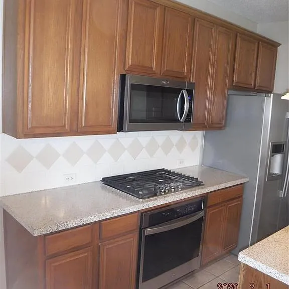 CUSTOM CABINETS, GAS COOKTOP, ELECTRIC OVEN AND MICROWAVE.