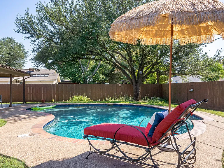Sparkling pool and cushioned lounge chair.