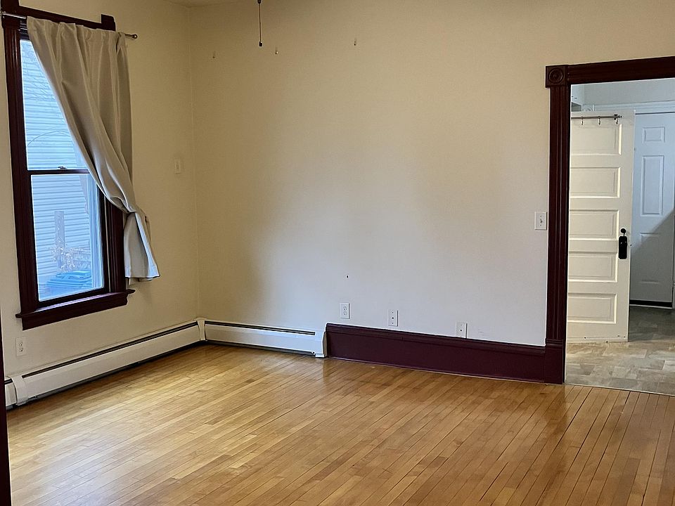 Living room with high ceilings, big windows, natural hardwood floors and ceiling fan