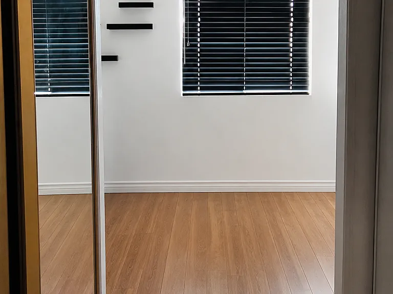 Modern primary bedroom featuring sleek black blinds and a contemporary light and ceiling fan combo with remote control functionality for added comfort and convenience.