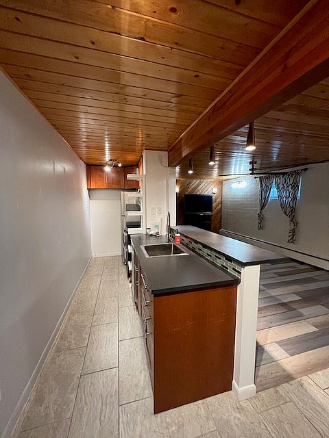 Kitchen has stainless steel appliances - refrigerator, microwave, stove, dishwasher, sink.