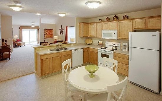 Modern kitchen with white Frigidaire appliances and maple ca