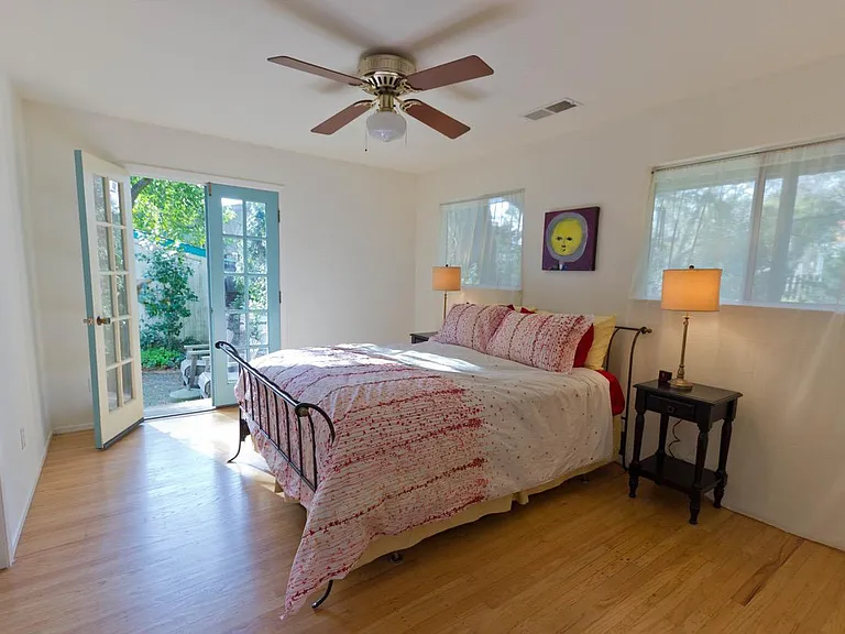 Master bedroom with french doors leading to sunny patio and gardens.